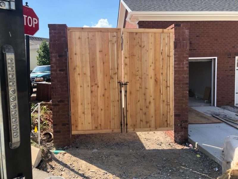 Pedestrian fence used to conceal garbage cans.